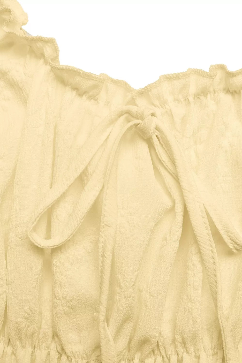 Light yellow top with ruffled details on a white background