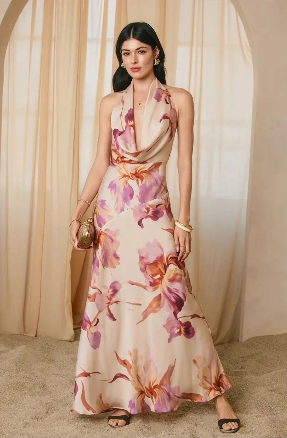Woman wearing a floral dress standing in front of beige curtains