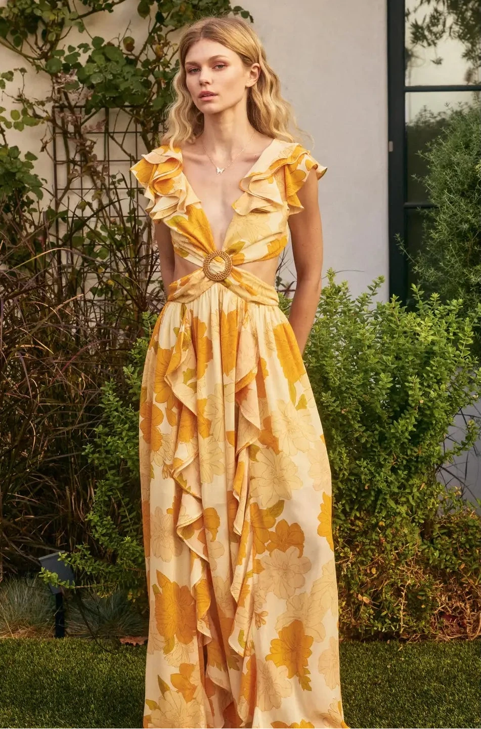 Woman wearing a yellow floral dress in an outdoor setting