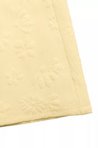 yellow quilted fabric on a white background
