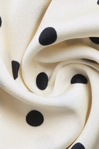 Close-up of cream fabric with black polka dots