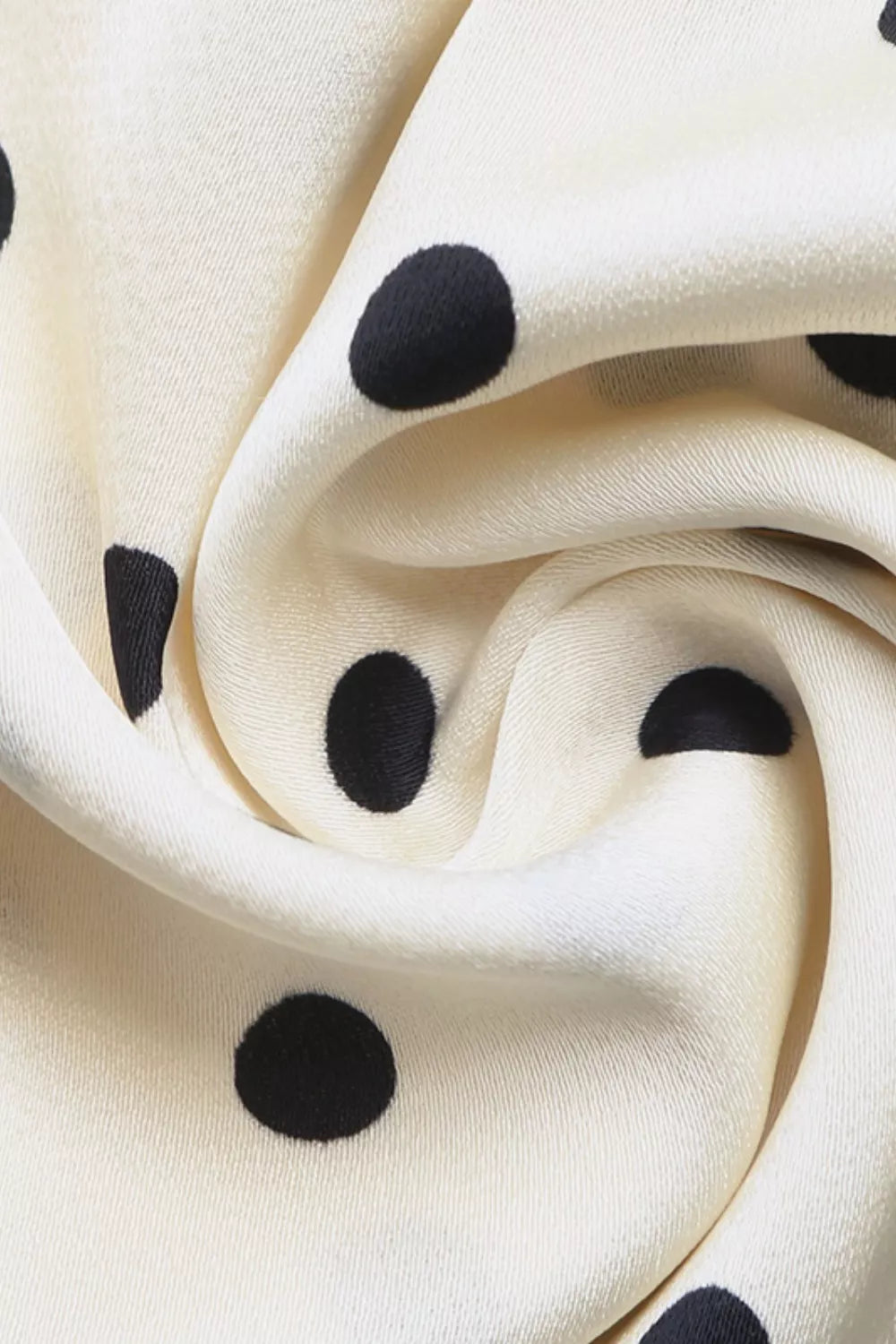 Close-up of cream fabric with black polka dots