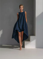 Woman wearing a navy blue dress against a gray background