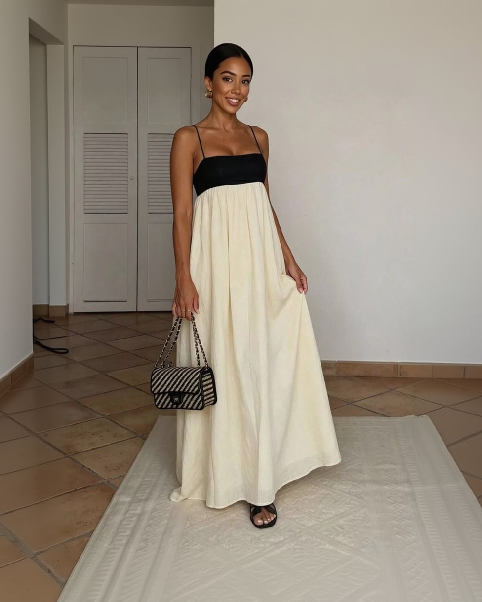 Woman wearing a black and white dress holding a zebra-striped handbag indoors.