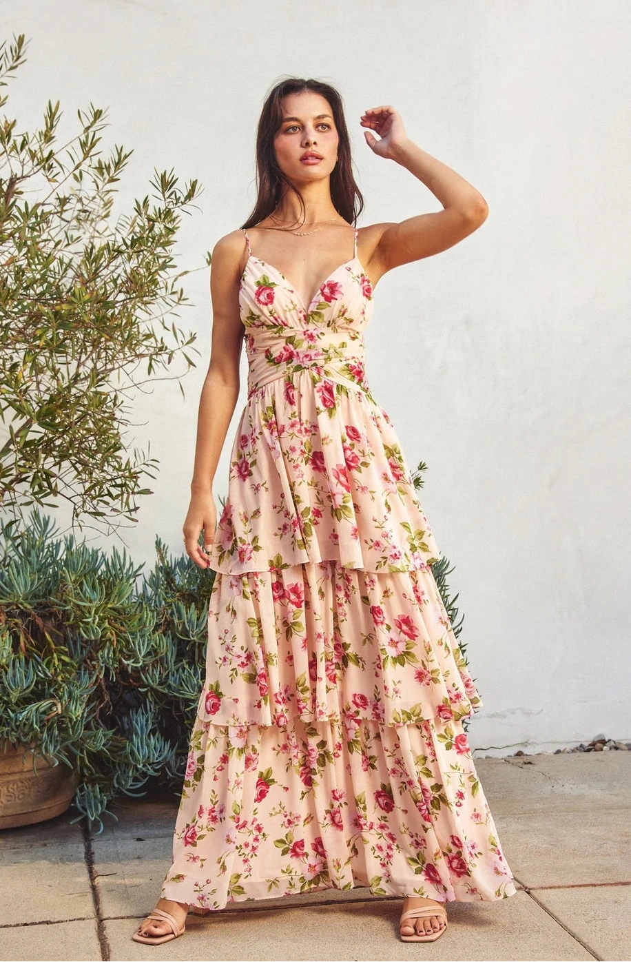 Woman wearing a floral dress standing outdoors with plants in the background