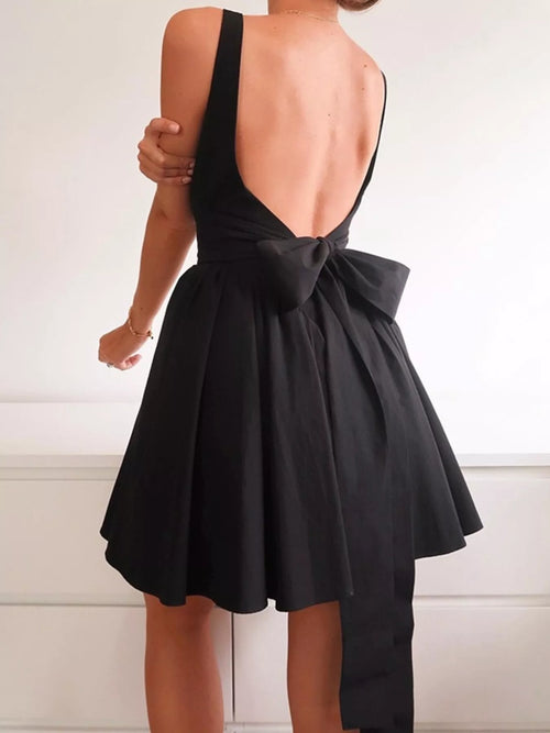 Black dress with open back and bow detail on a white background