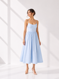 Woman wearing a light blue dress against a white background
