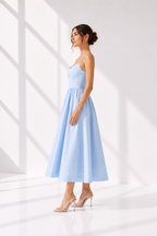 Woman wearing a light blue dress against a white background