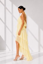 Woman wearing a yellow dress in a bright, minimalistic setting