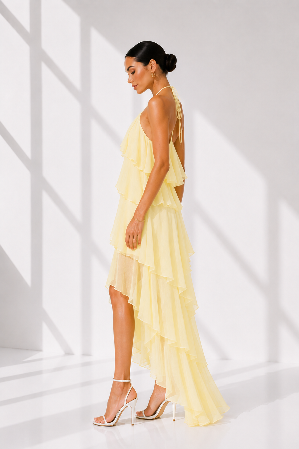Woman wearing a yellow dress in a bright, minimalistic setting