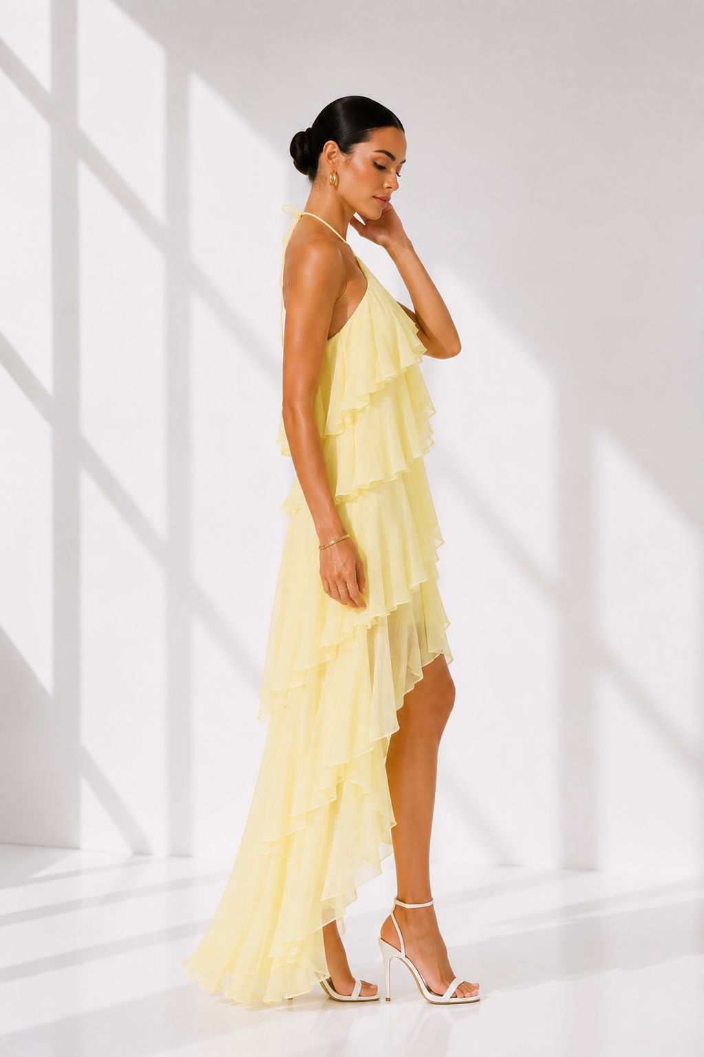 Woman wearing a yellow dress in a bright, minimalistic setting