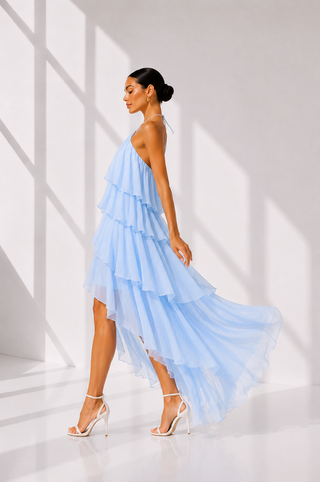 Woman wearing a light blue, one-shoulder dress in a bright setting