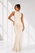 Woman wearing a beige evening gown against a white background