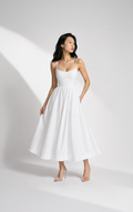 Woman wearing a white dress on a plain background
