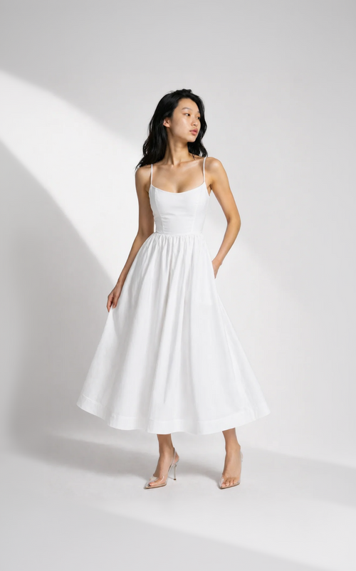 Woman wearing a white dress on a plain background