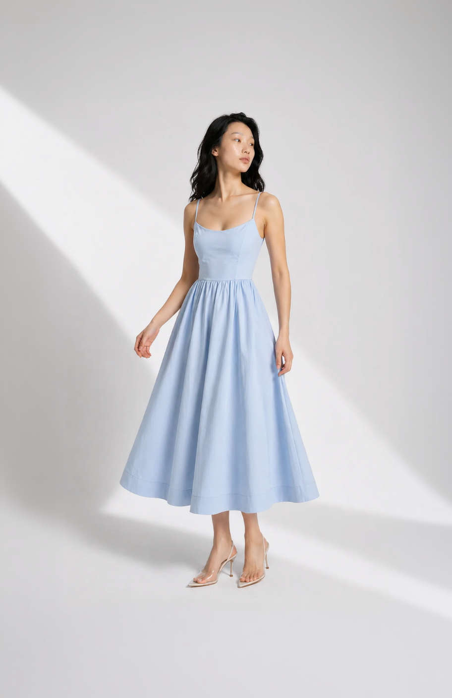 Woman wearing a light blue dress against a white background