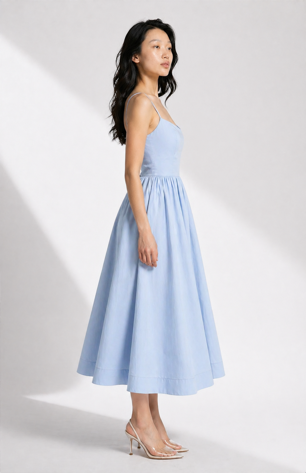 Woman wearing a light blue dress against a white background