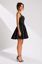 Woman wearing a black dress on a white background