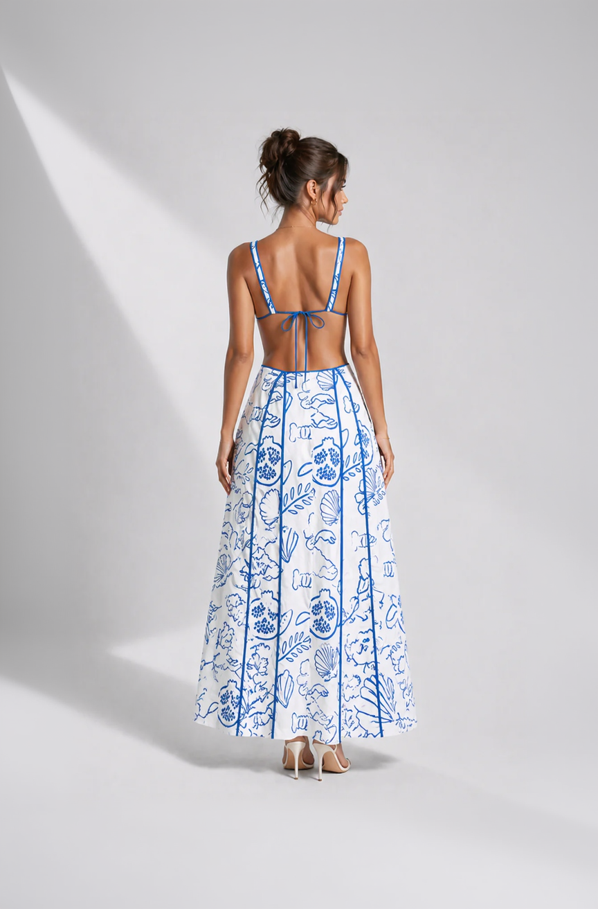 Woman wearing a blue and white floral dress on a gray background