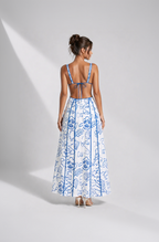 Woman wearing a blue and white floral dress on a gray background