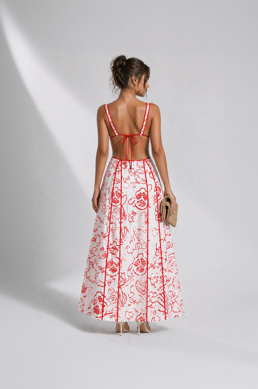 Woman wearing a red and white floral dress with a plain background