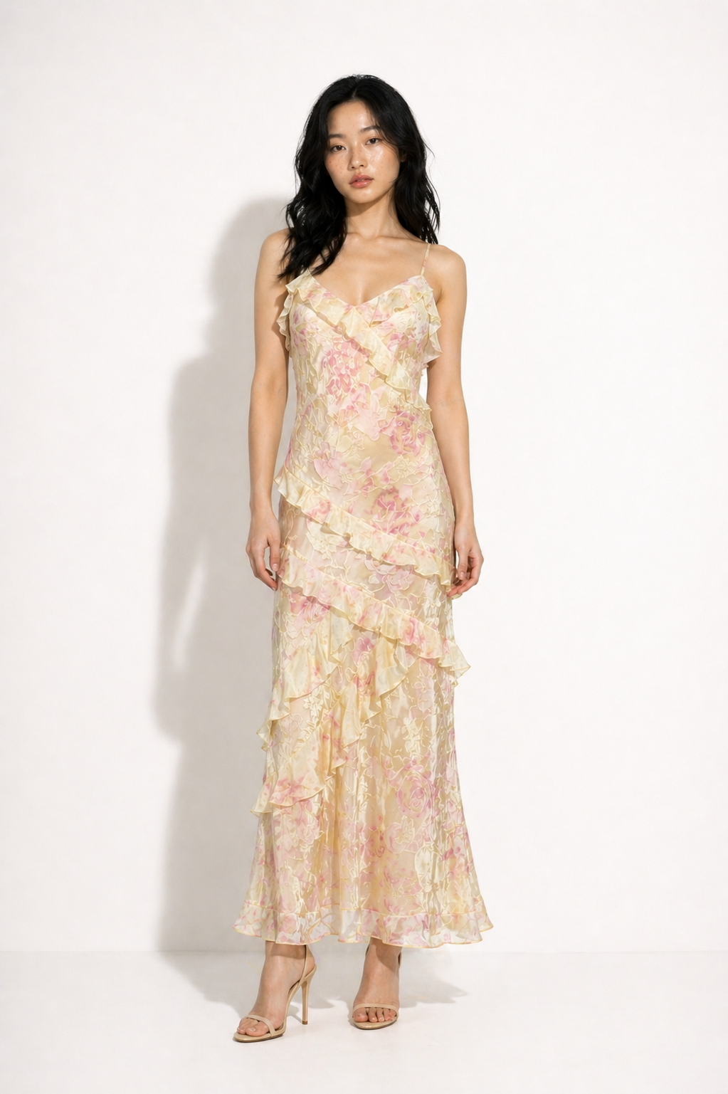 Woman wearing a floral one-shoulder dress on a white background
