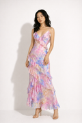 Woman wearing a pastel floral dress against a white background