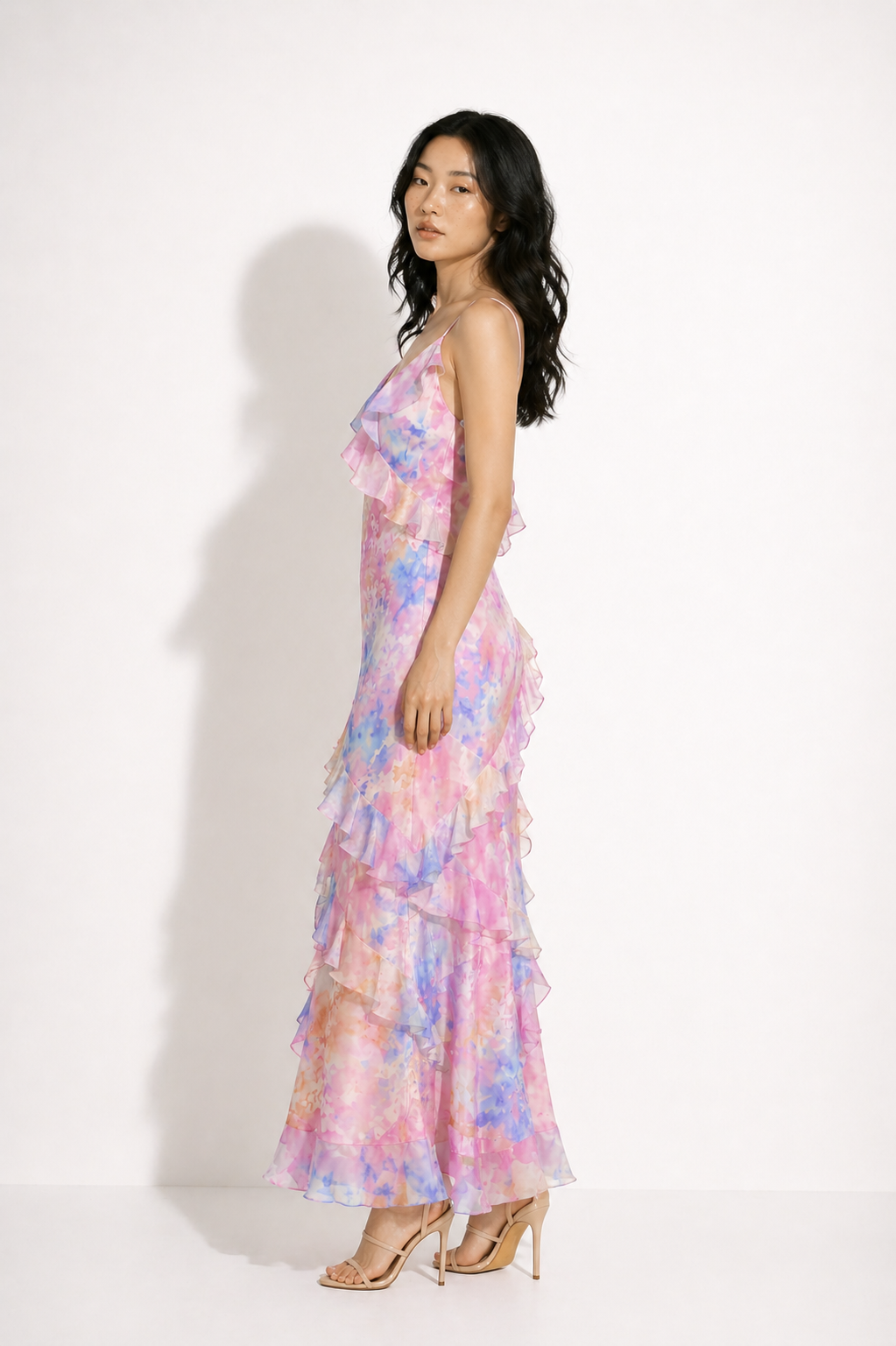 Woman wearing a colorful floral dress against a white background