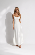 Woman wearing a white dress against a plain background