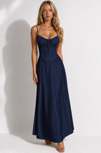 Woman wearing a navy blue dress against a white background