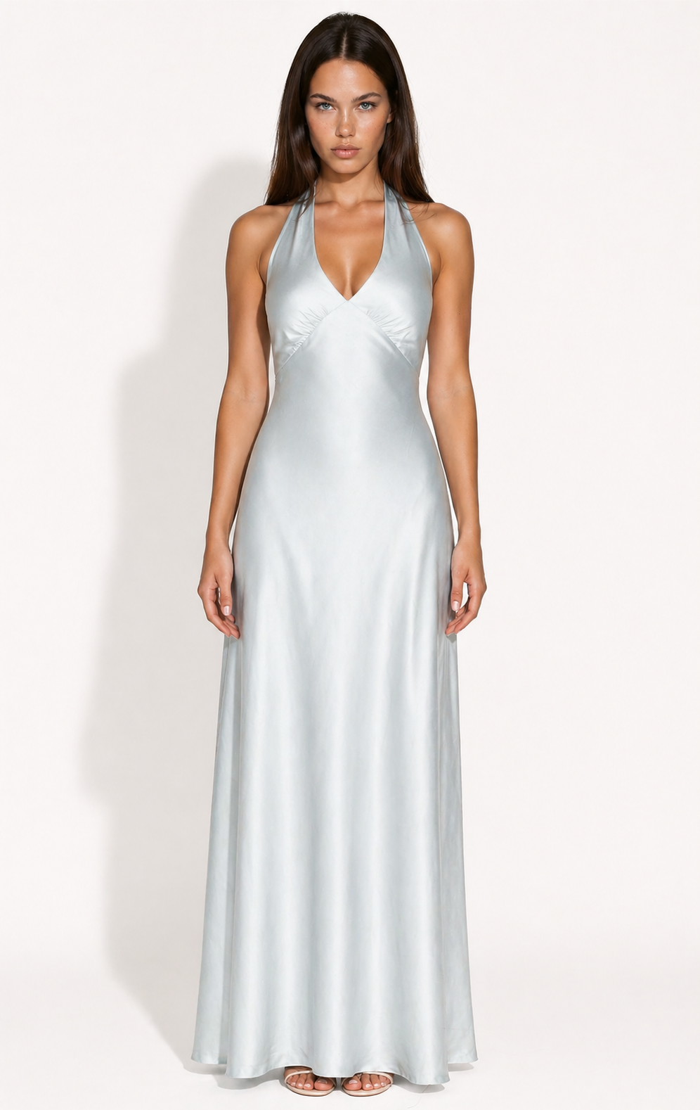 Woman wearing a blue halter neck gown against a white background