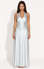 Woman wearing a blue halter neck gown against a white background