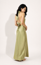 Woman wearing a green dress with a bow detail on a white background