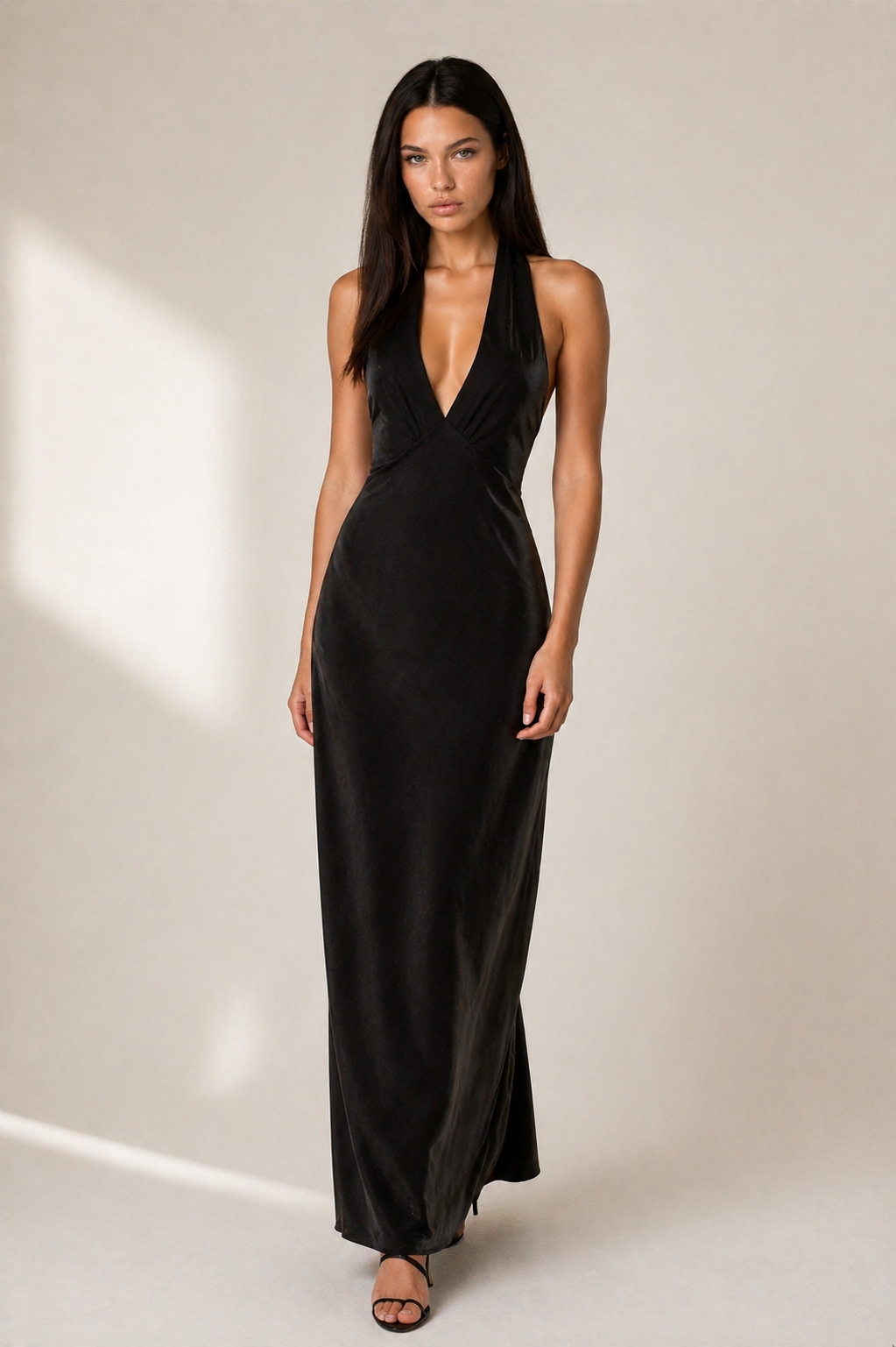 Woman wearing a black evening gown against a neutral background