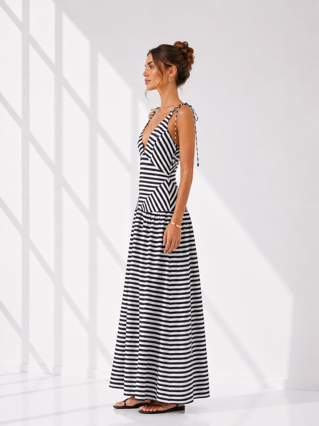 Woman wearing a black and white striped dress against a white background