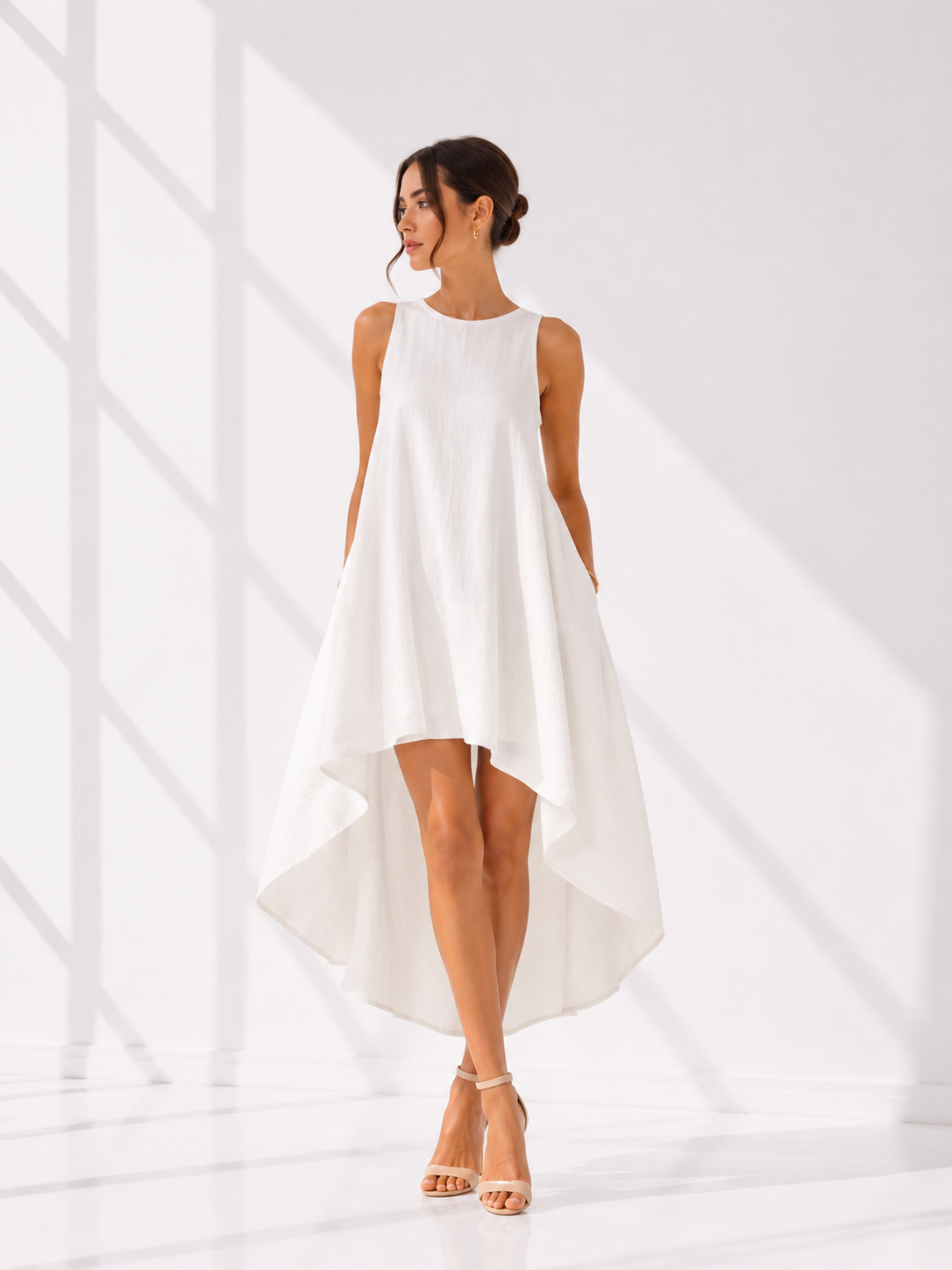 Woman wearing a white sleeveless dress against a white background