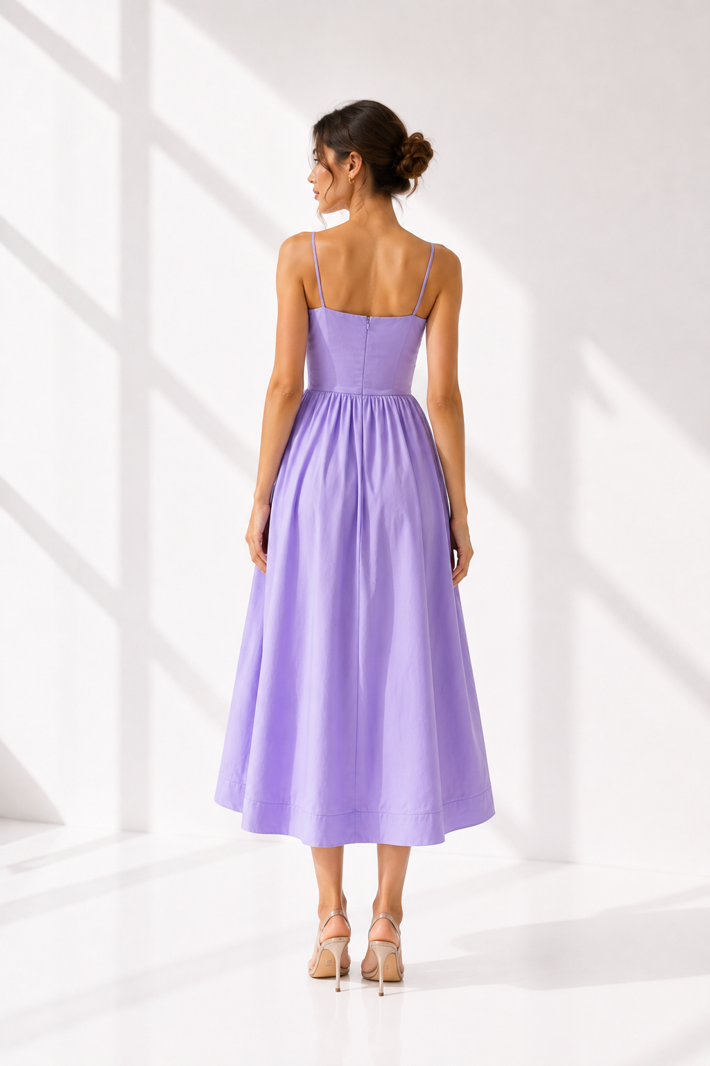 Woman wearing a purple dress standing against a white background