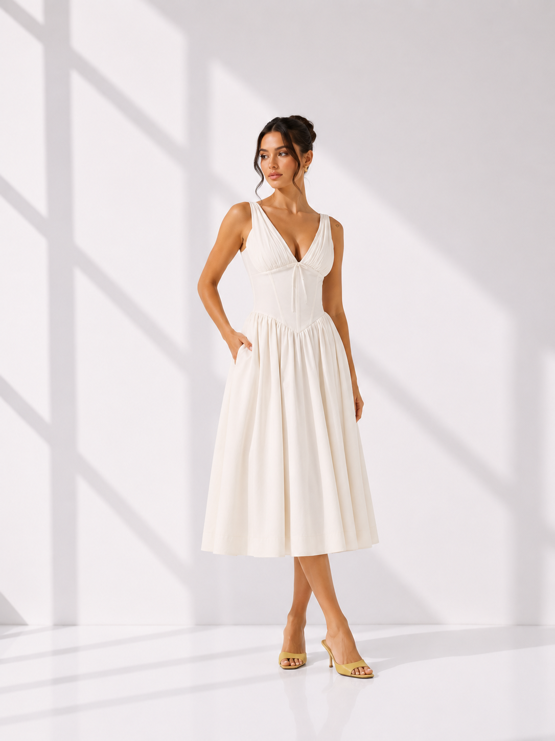 Woman wearing a white dress in a bright, minimalistic setting