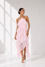 Woman wearing a pink ruffled dress against a white background