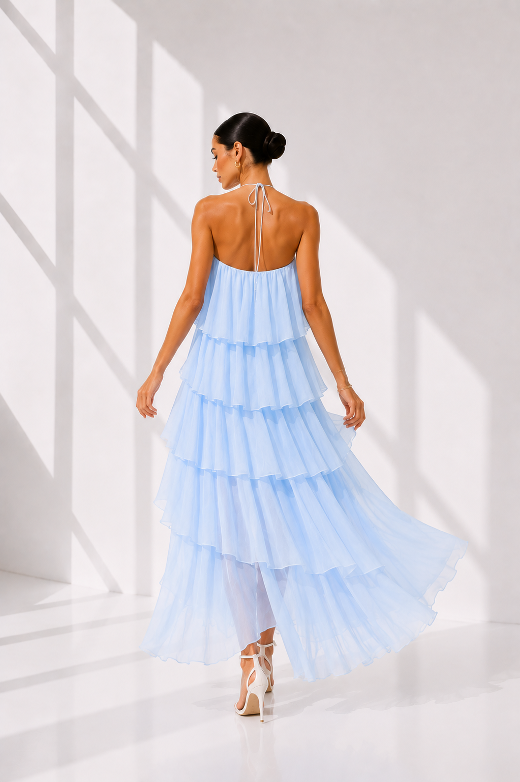 Woman wearing a light blue, one-shoulder dress in a bright setting