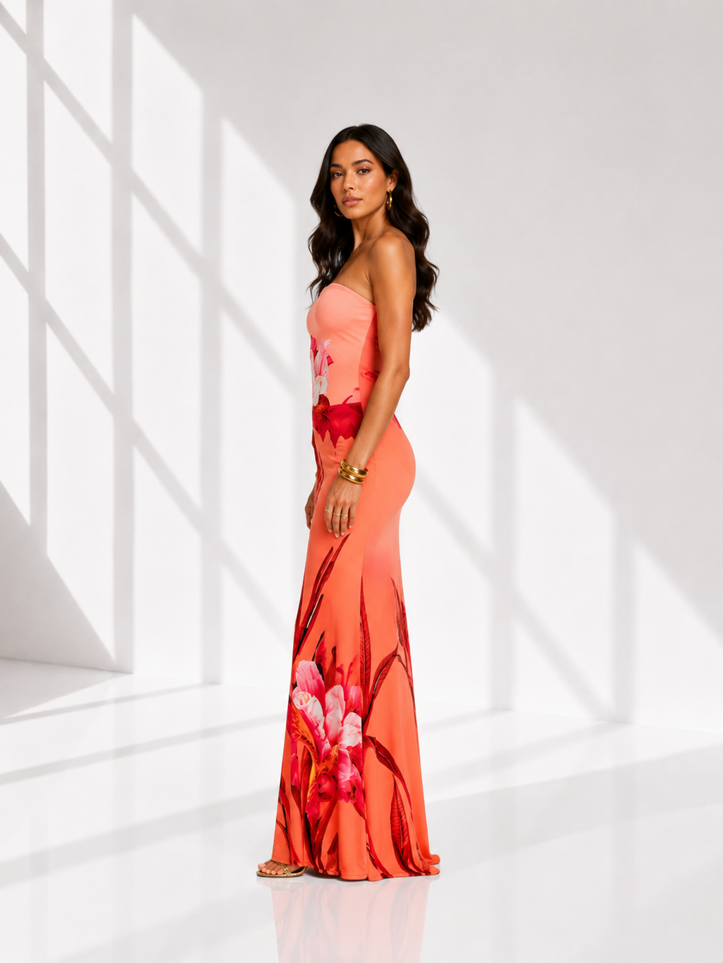 Woman wearing a floral dress standing in a bright, minimalistic room.