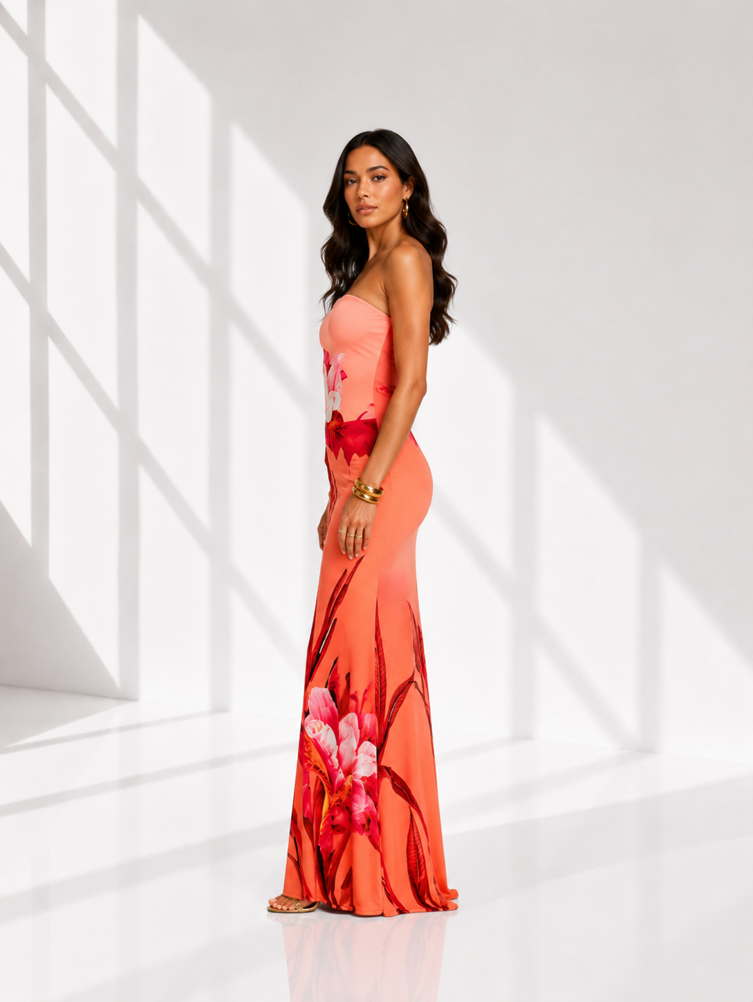 Woman wearing a floral dress standing in a bright, minimalistic room.