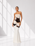 Woman wearing a strapless dress with a unique pattern in a bright, minimalistic setting