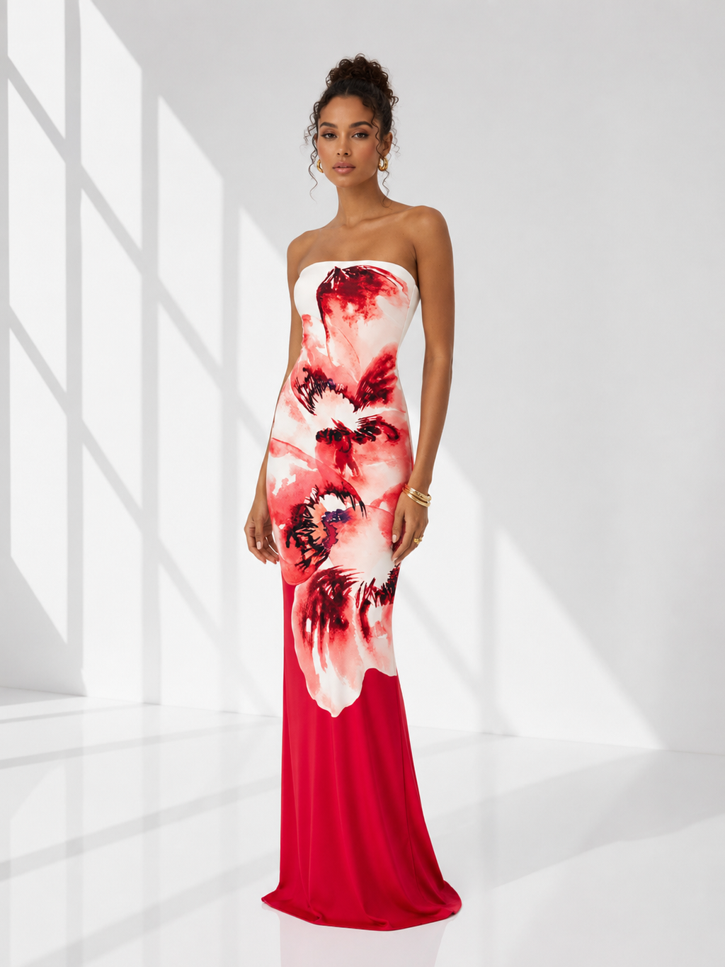 Woman wearing a strapless red and white floral dress in a bright room.