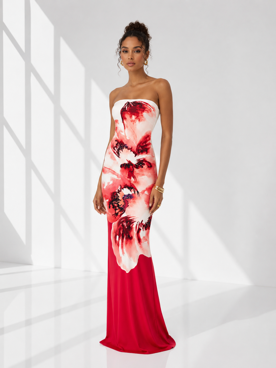 Woman wearing a strapless red and white floral dress in a bright room.