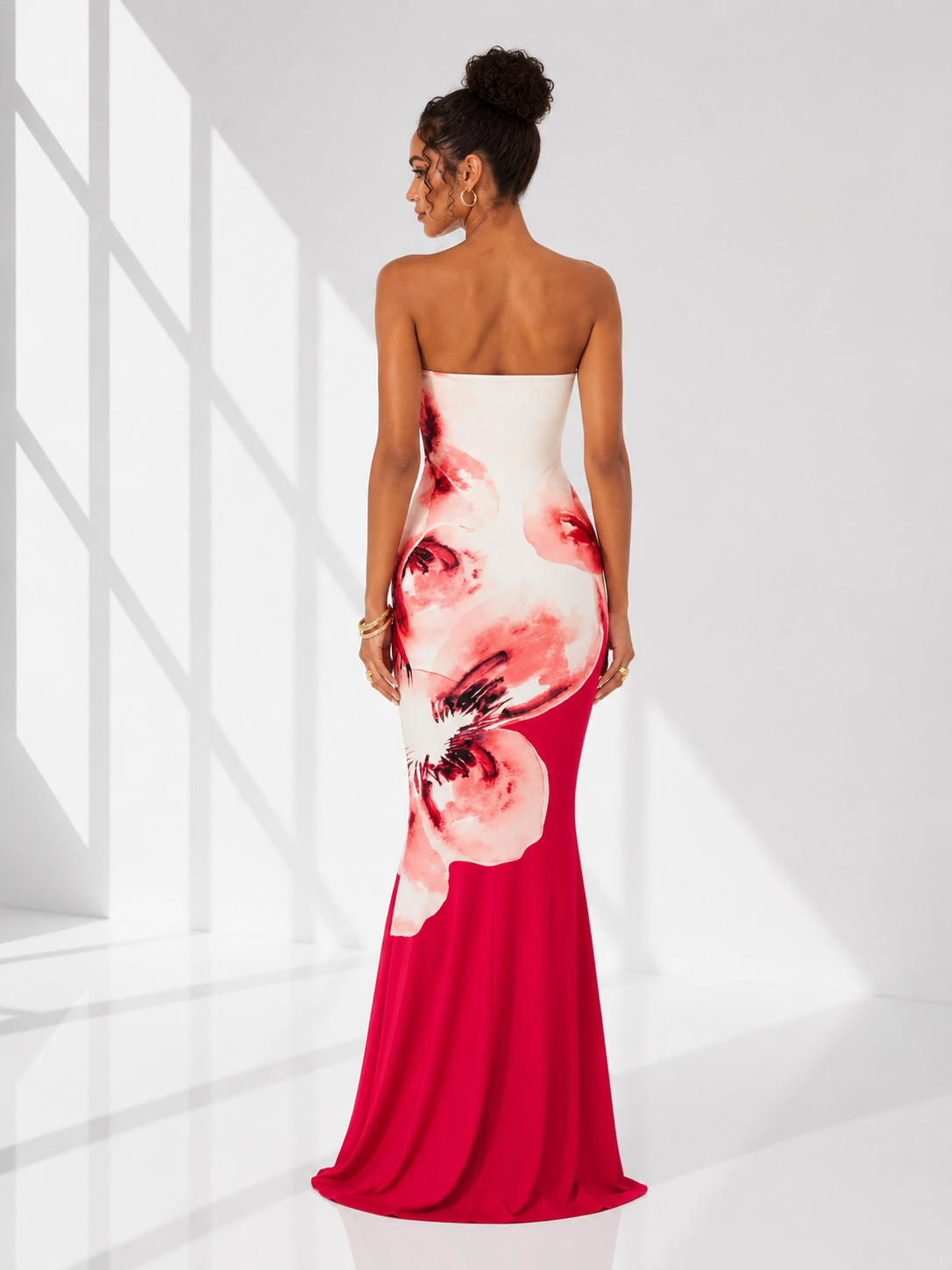 Woman wearing a strapless dress with floral design in a bright room