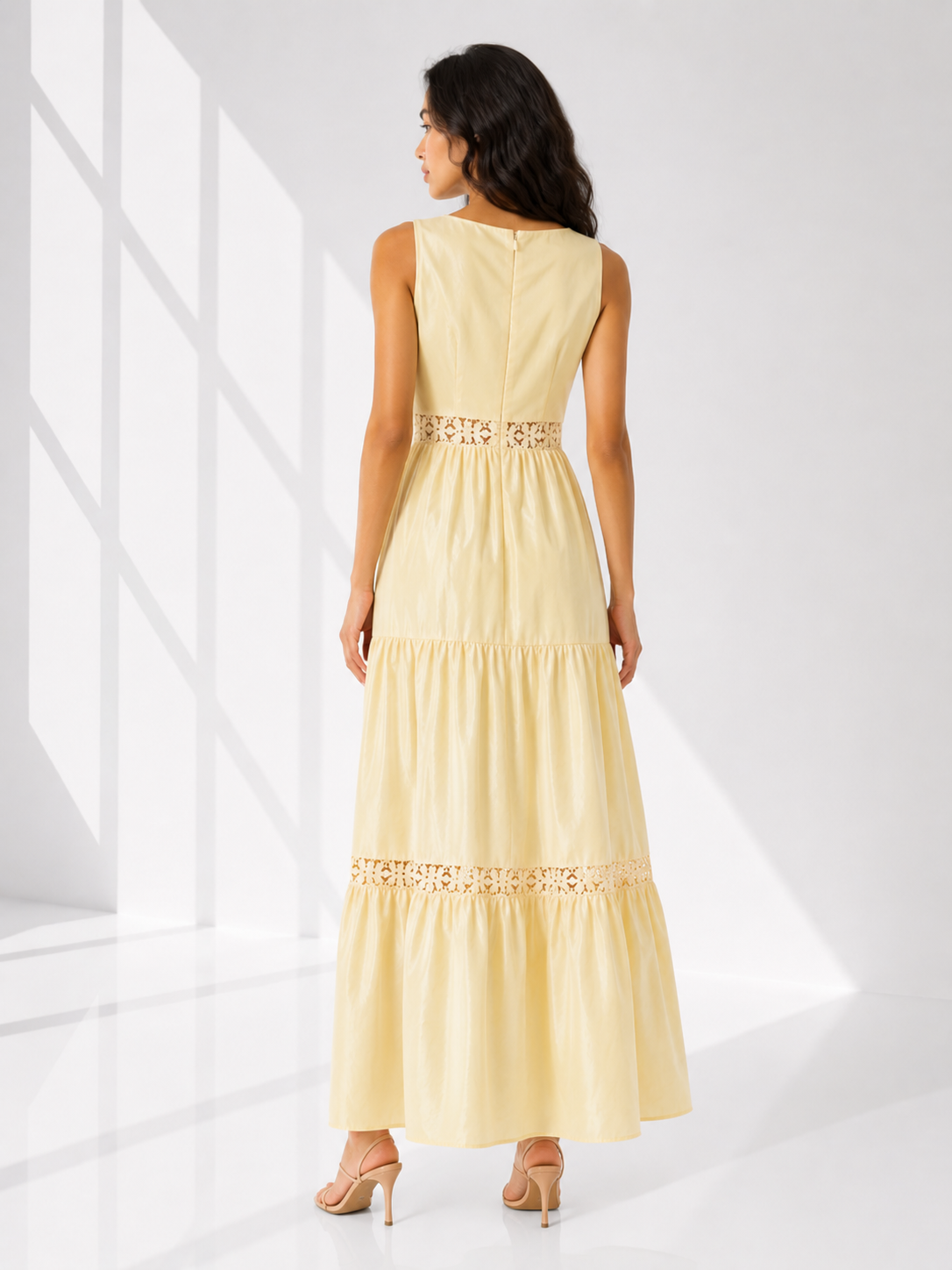 Woman wearing a light yellow dress with decorative elements on a white background
