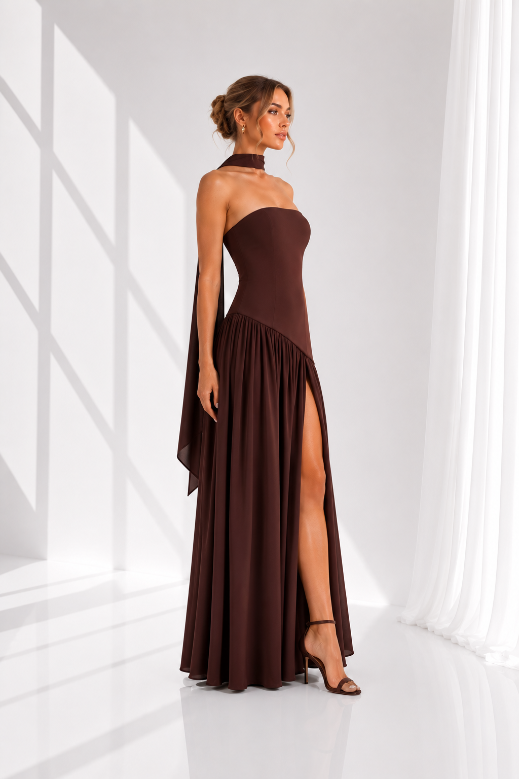 Woman wearing a brown strapless dress with a slit in a minimalistic setting