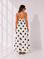 Woman wearing a polka dot dress in a minimal white room