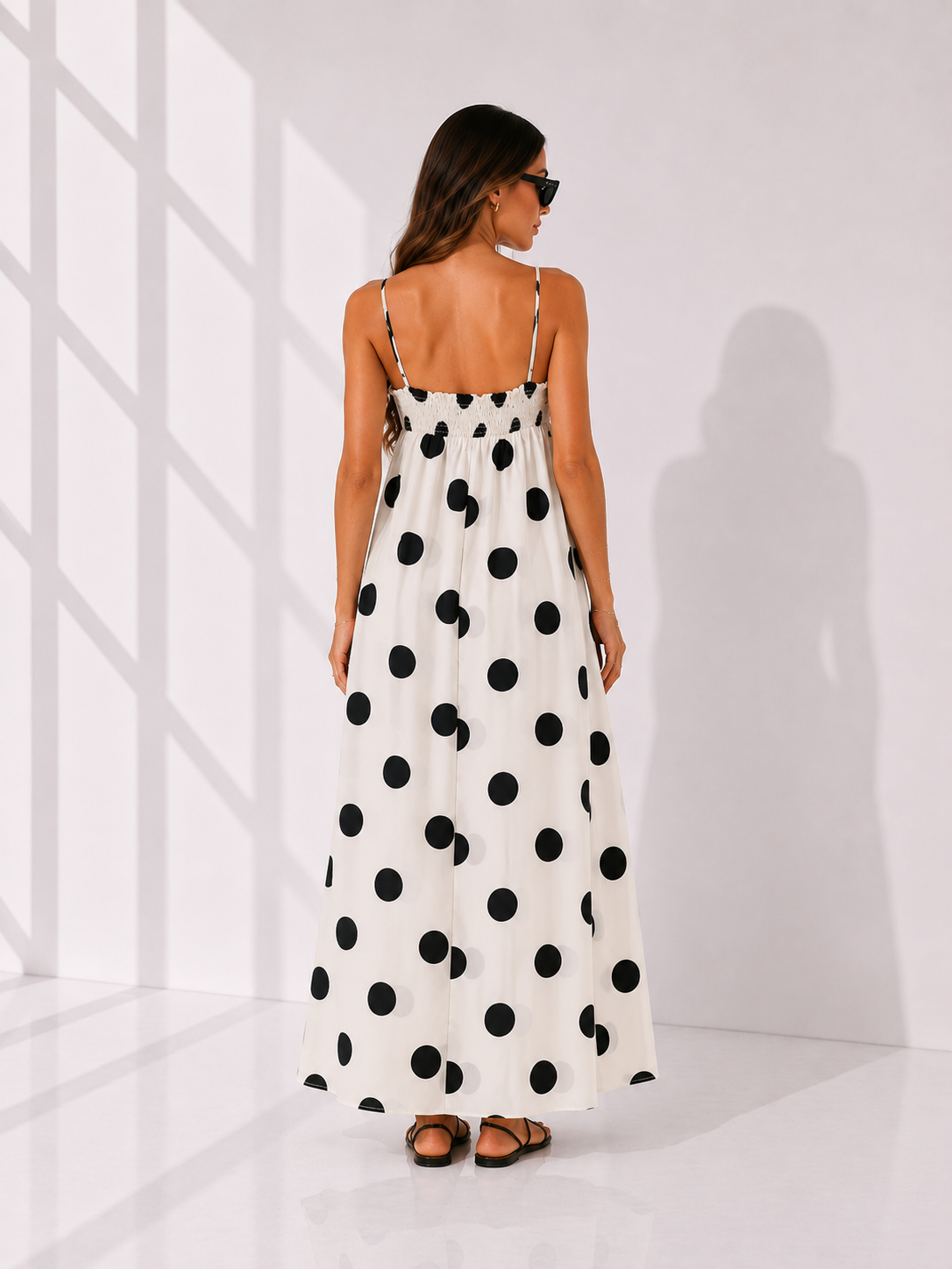 Woman wearing a polka dot dress in a minimal white room